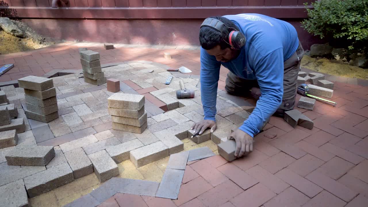 Man laying bricks for outdoor pavement construction