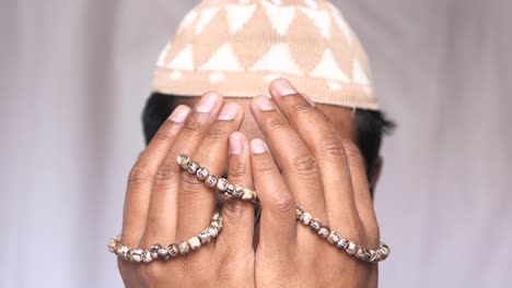 young muslim man praying indoor, close