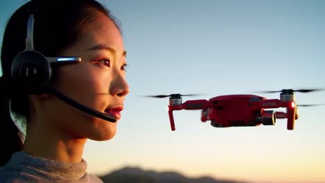 a woman interacts with a sleek drone at sunset, showcasing the blend of technology and nature as she engages in a modern aerial experience with advanced equipment.
