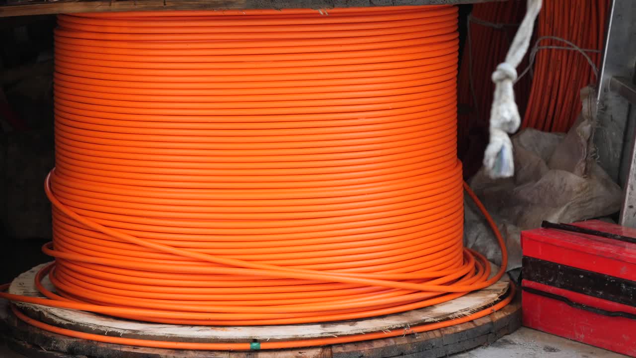 un gran carrete de cable de fibra óptica naranja