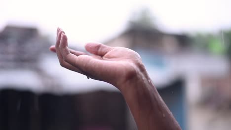 Mano-De-Niña-Atrapando-Gotas-De-Lluvia-Cayendo,-Extrañando-A-Alguien,-Primer-Plano-De-La-Mano