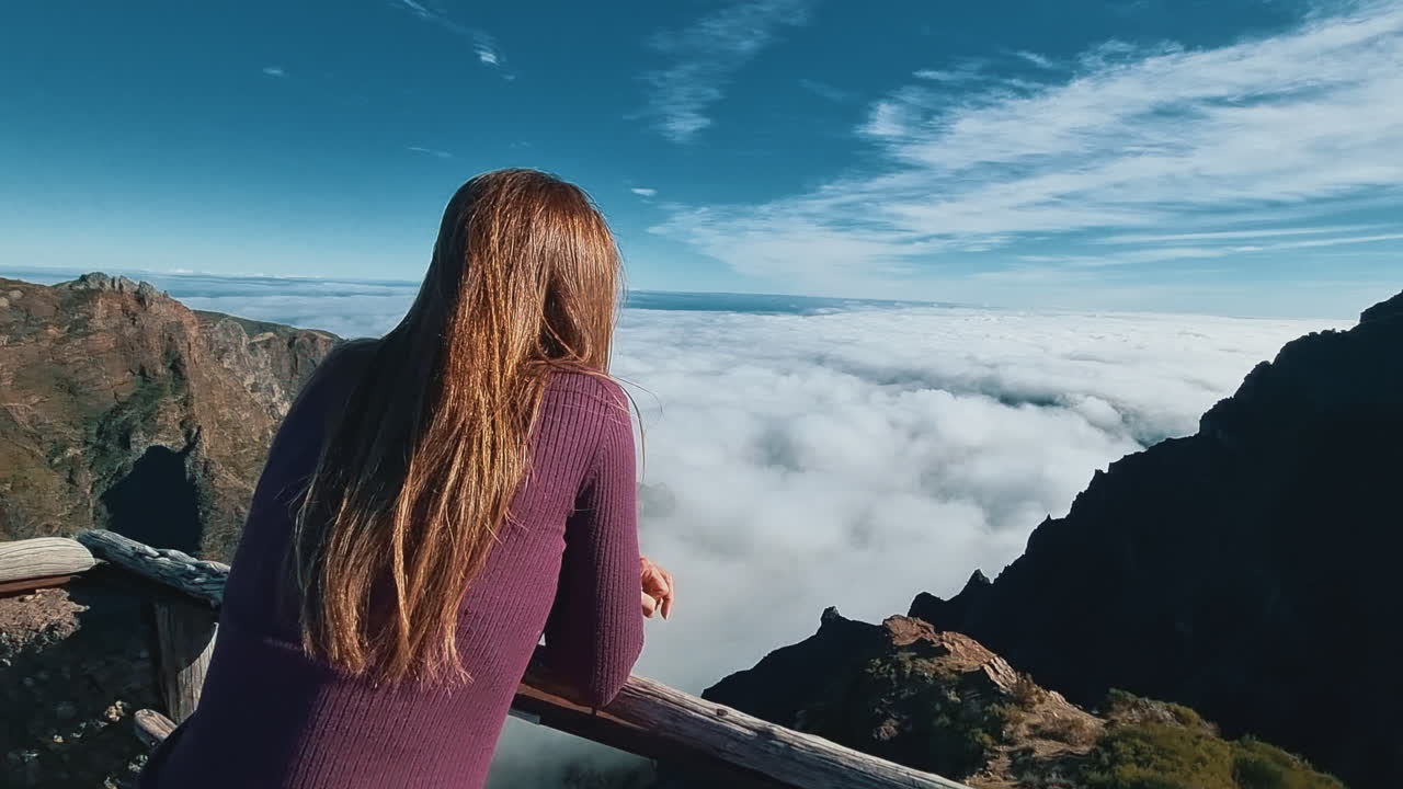 Frau genießt die atemberaubende Aussicht auf die Berge über den Wolken in Madeira, Portugal