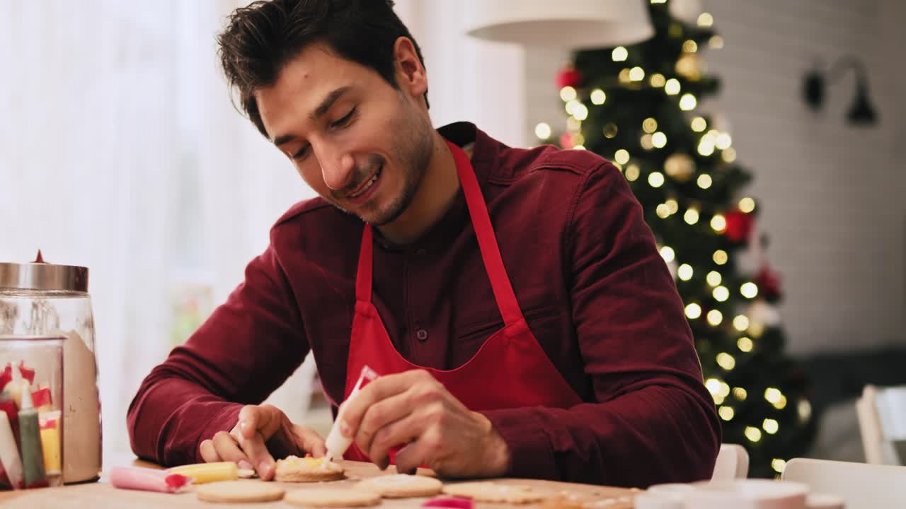 vista de la mano de un hombre decorando galletas de navidad