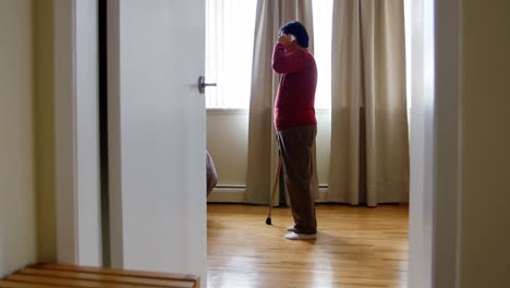 Senior-woman-talking-on-mobile-phone-in-living-room