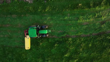 overhead view of tractor working in the vast, open field in sao miguel island, portugal - aerial