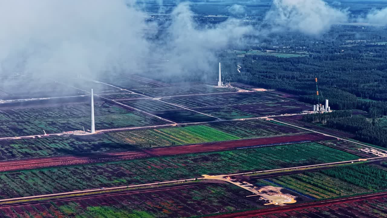 Wind turbine green energy production farm under construction in various stages, aerial