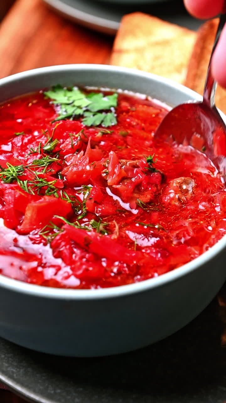Ukrainian borscht with beef and herbs in bowl. Hearty beet soup with beef, cabbage, and dill served fresh