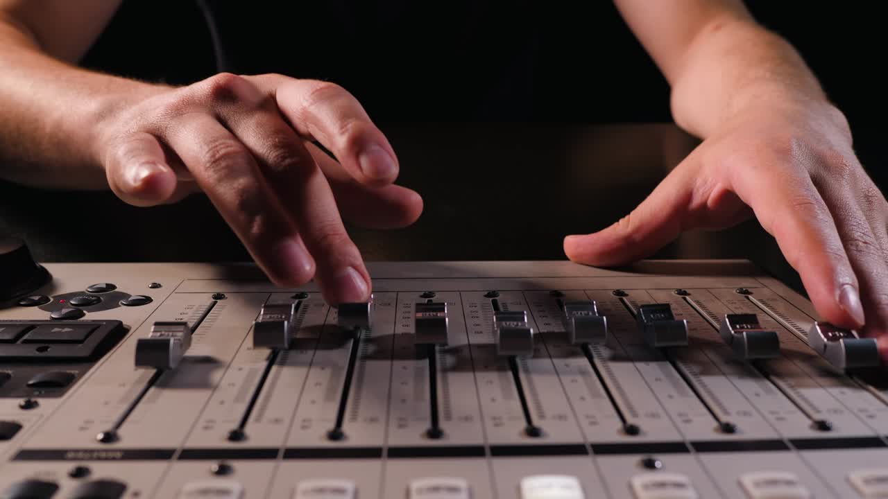 디지털 오디오 서 콘솔에서 녹음 스튜디오에서 일하는 오디오 엔지니어, 그의 손이 손잡이를 끌고, 증폭기 및 소리의 균형을위한 전자, 쇼, 4k, 느린 모션