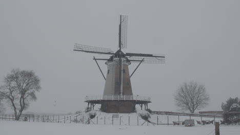 dolly in of windmill in snow covered landscape