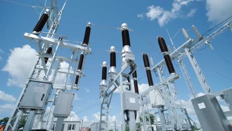 many high voltage electrical insulators in power substation against blue sky background