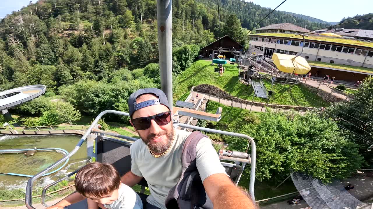 Padre e figlio su una seggiovia in un parco acquatico