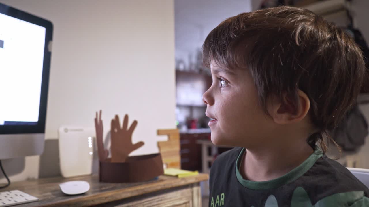 acercarse a un niño caucásico, ver clases de computación, hacer clases a distancia durante el bloqueo del coronavirus, usar su pijama