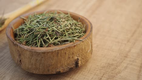 dried rosemary in a wooden bowl