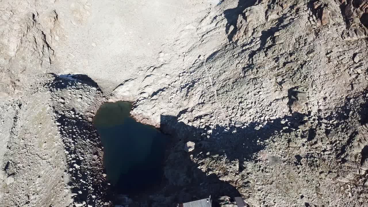 湖の隣にある岩山のあるスイスアルプスの小屋