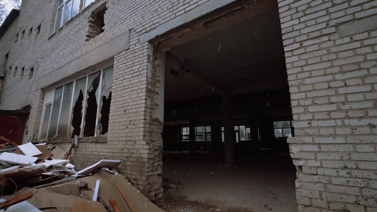 A pile of debris from the construction lying on the ground outside of a brick building. Entering the big hall with columns inside.