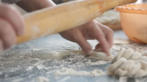 making meat dumpling with wooden rolling pin.