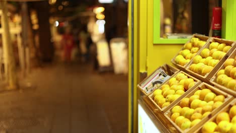 un puesto de frutas en una calle bulliciosa por la noche