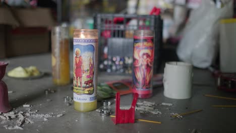 dos velas encendidas en el suelo rodeadas de muchas cosas