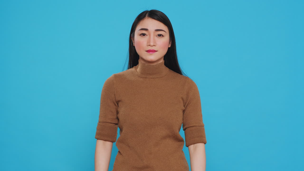 Asian maid smiling at camera while putting rubber glove after finishing house cleaning