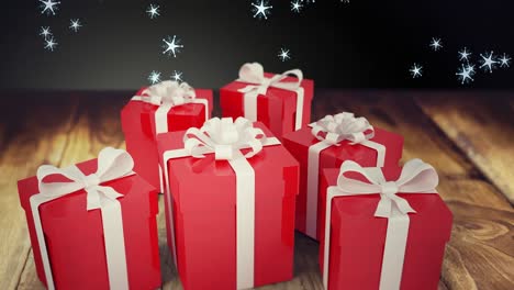 Animation-of-snow-falling-over-christmas-presents-on-wooden-and-black-background