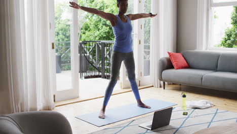 african american woman performing stretching exercise at home