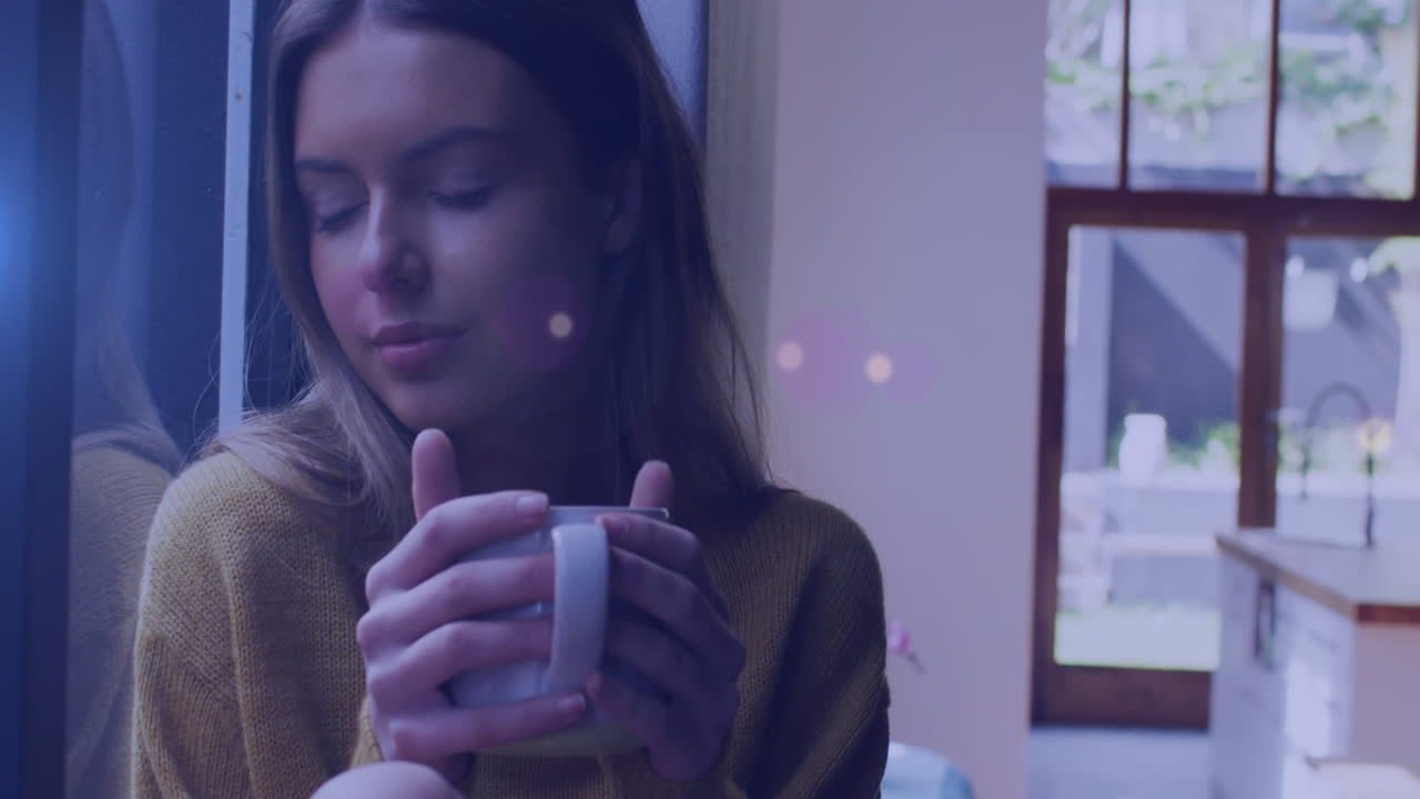 animación de puntos de luz sobre una mujer caucásica bebiendo café en casa