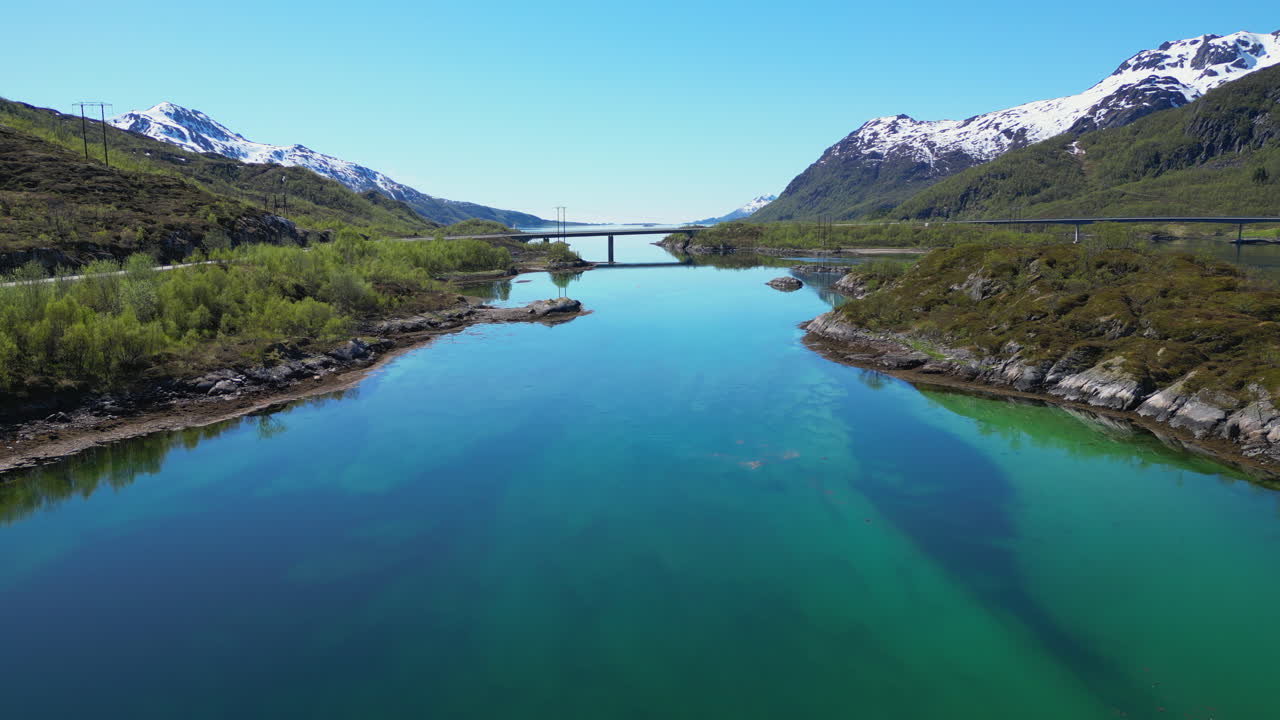 Stunning turquoise fjord water reflecting majestic mountains and bridge, capturing serene Lofoten Islands landscape in Norway's pristine natural setting