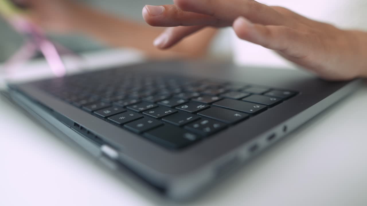 Close-up of Hands Typing on Laptop Keyboard