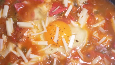 fried egg with tomato sauce, sausage, and cheese