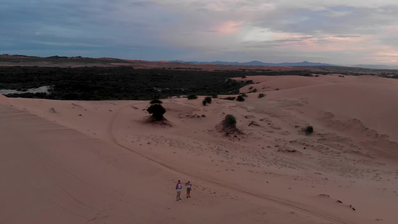손길이 닿지 않은 모래와 흐린 하늘-2가 있는 베트남의 외딴 모래 언덕 위로 황금빛 일출의 영화 같은 공중 드론 샷