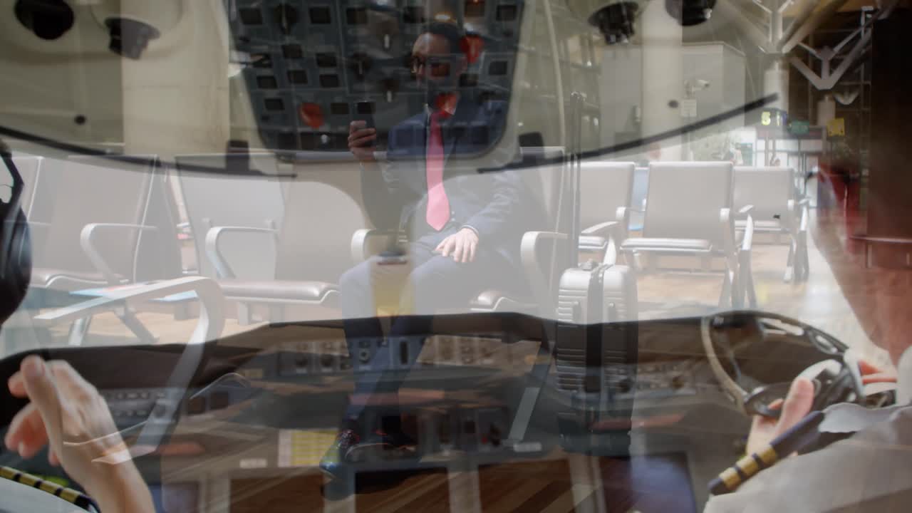 스마트폰을 사용하는 아프리카계 미국인 사업가들 위의 조종실에 있는 두 남성 조종사의 복합 비디오