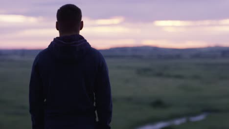 hombre contemplando el amanecer sobre un campo