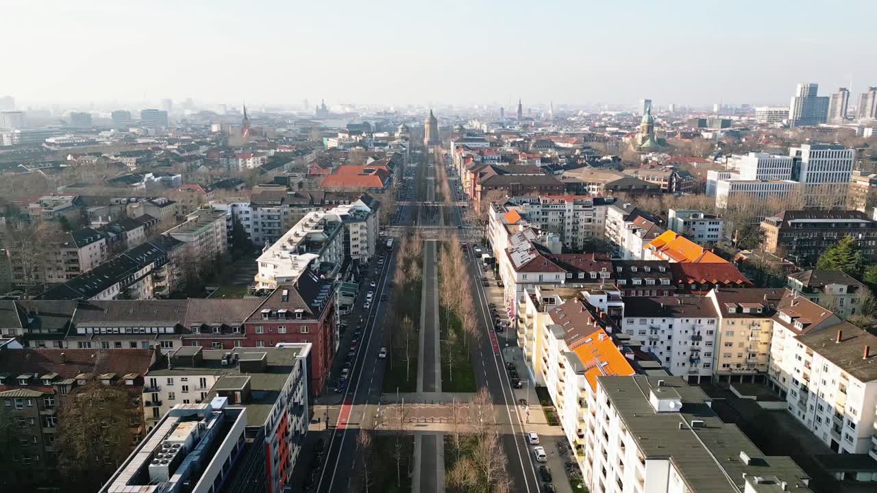 Drone flight over Mannheim's Augustaanlage towards the iconic Wasserturm on a clear, sunny winter day.