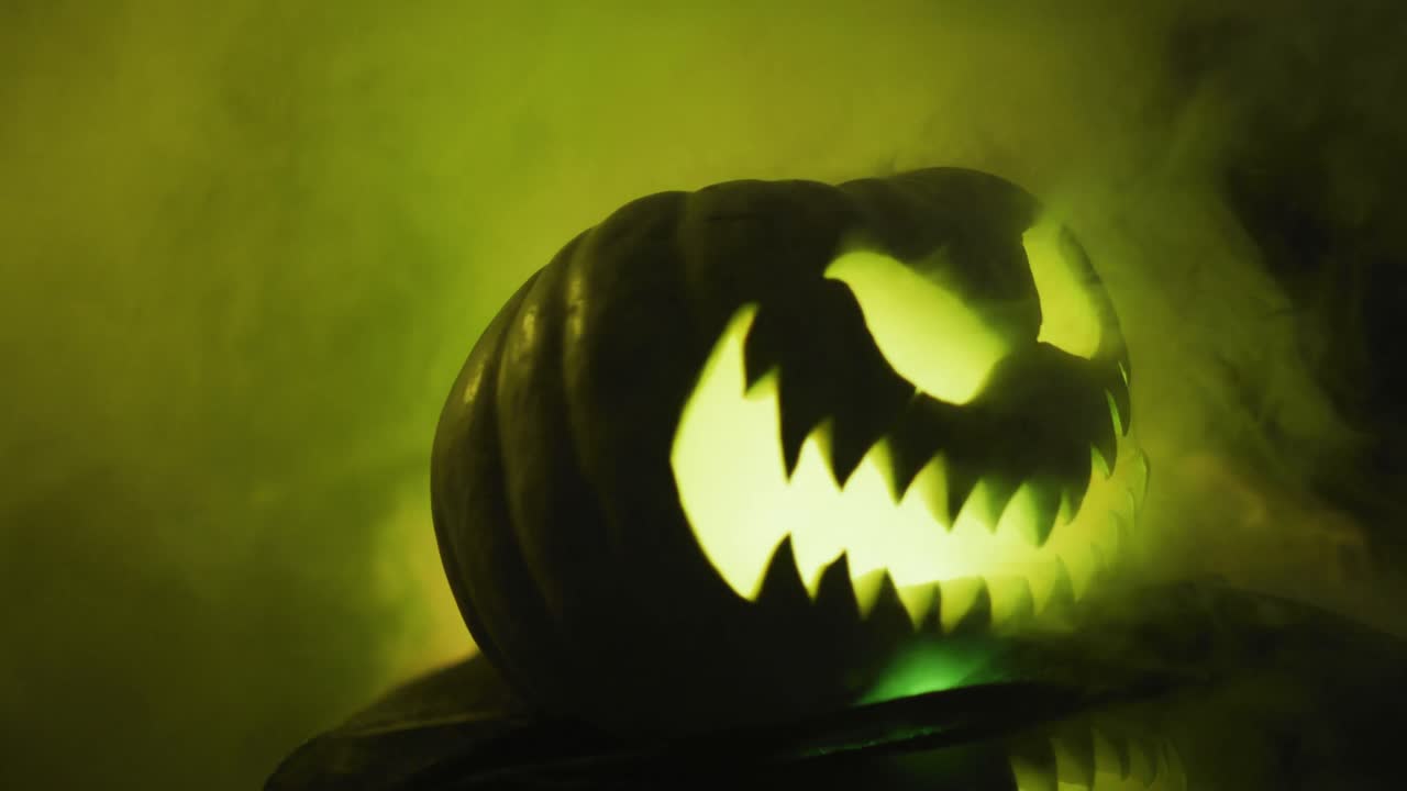 video de calabaza tallada de halloween con humo y luz verde sobre fondo negro