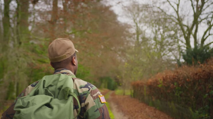 Rear View Of American Soldier In Uniform Carrying Kitbag Returning Home On Leave