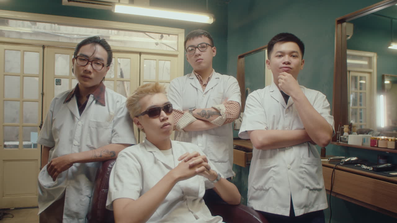 Team of Asian Barbers Posing on Camera in Retro Barbershop