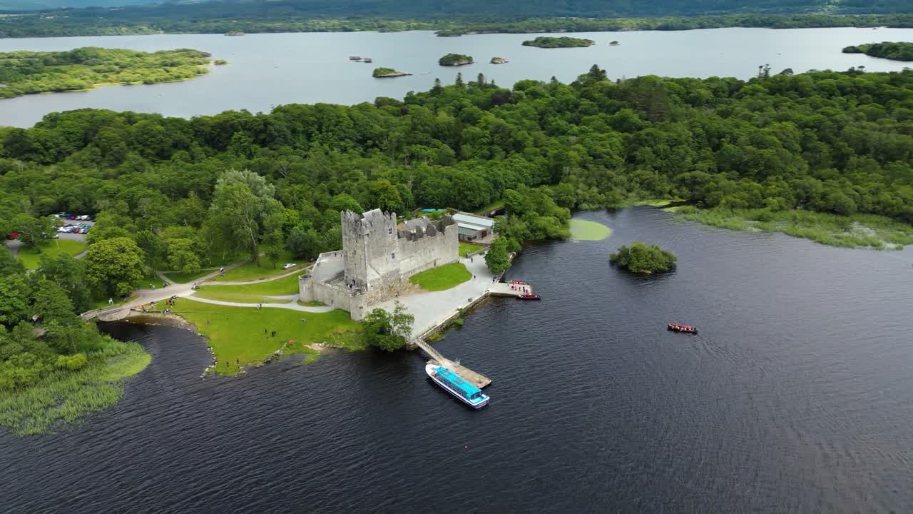 4K Aerial view of Ross Castle, capturing the historic stone walls, surrounding lakeshore, and lush green landscapes of Killarney National Park. Kerry_03