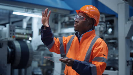 analyst using modern glass tablet computer at machinery factory. hitech concept