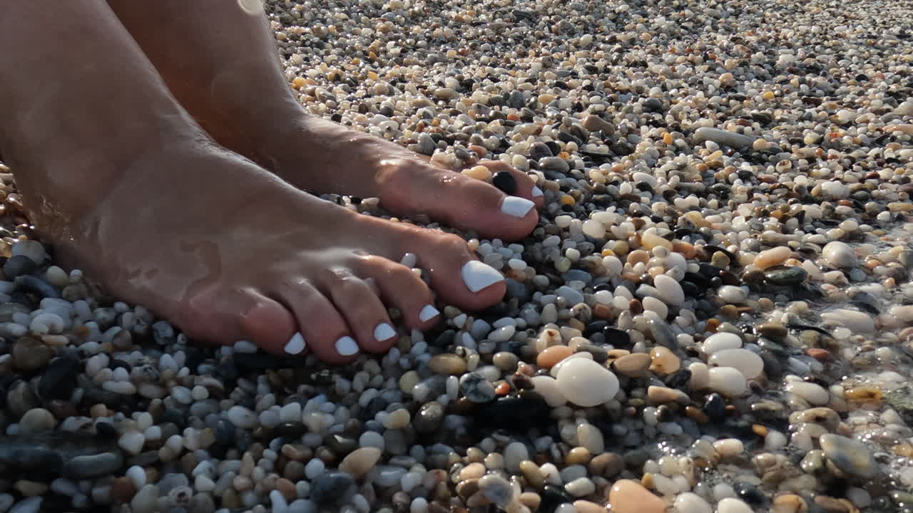 Piedi di donna nella spuma del mare