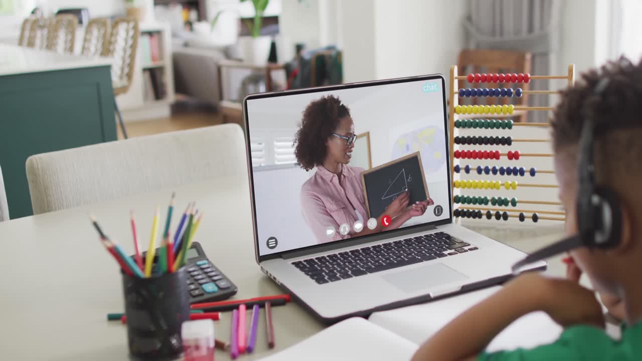 escolar afroamericano teniendo una llamada de video portátil con una maestra en cámara lenta