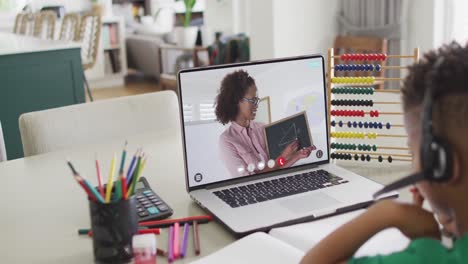afrikanisch-amerikanischer schuljunge hat einen laptop-videogespräch mit einer lehrerin in slowmotion