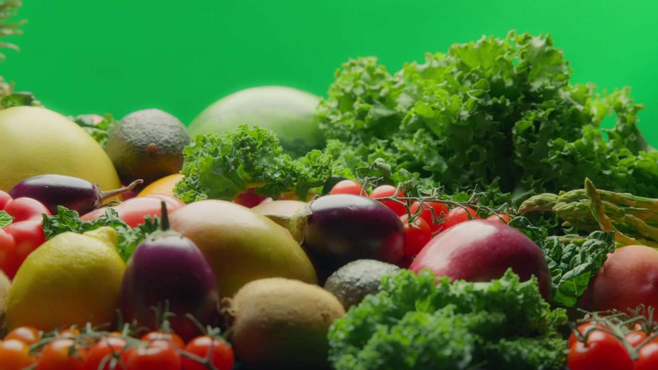 Varietà di frutta e verdura fresca su sfondo verde. Movimento lento, carrello