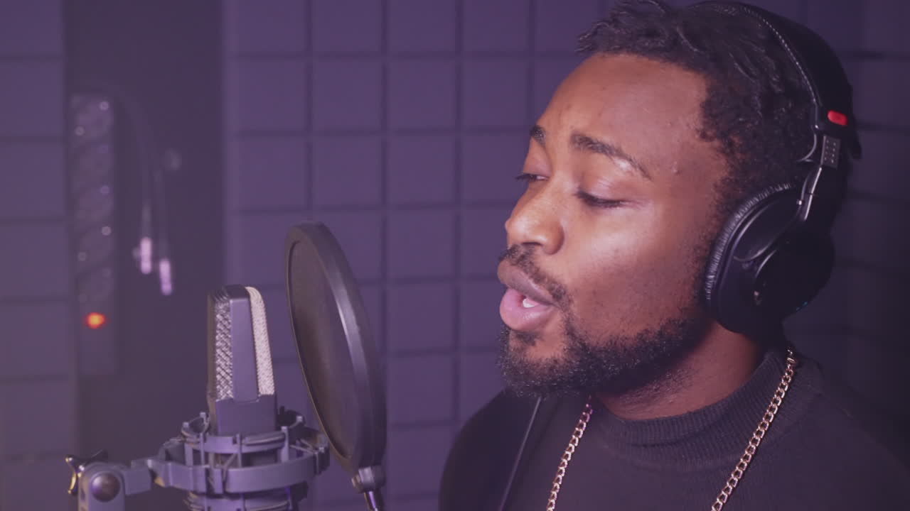 hombre cantando en el micrófono en el estudio de grabación