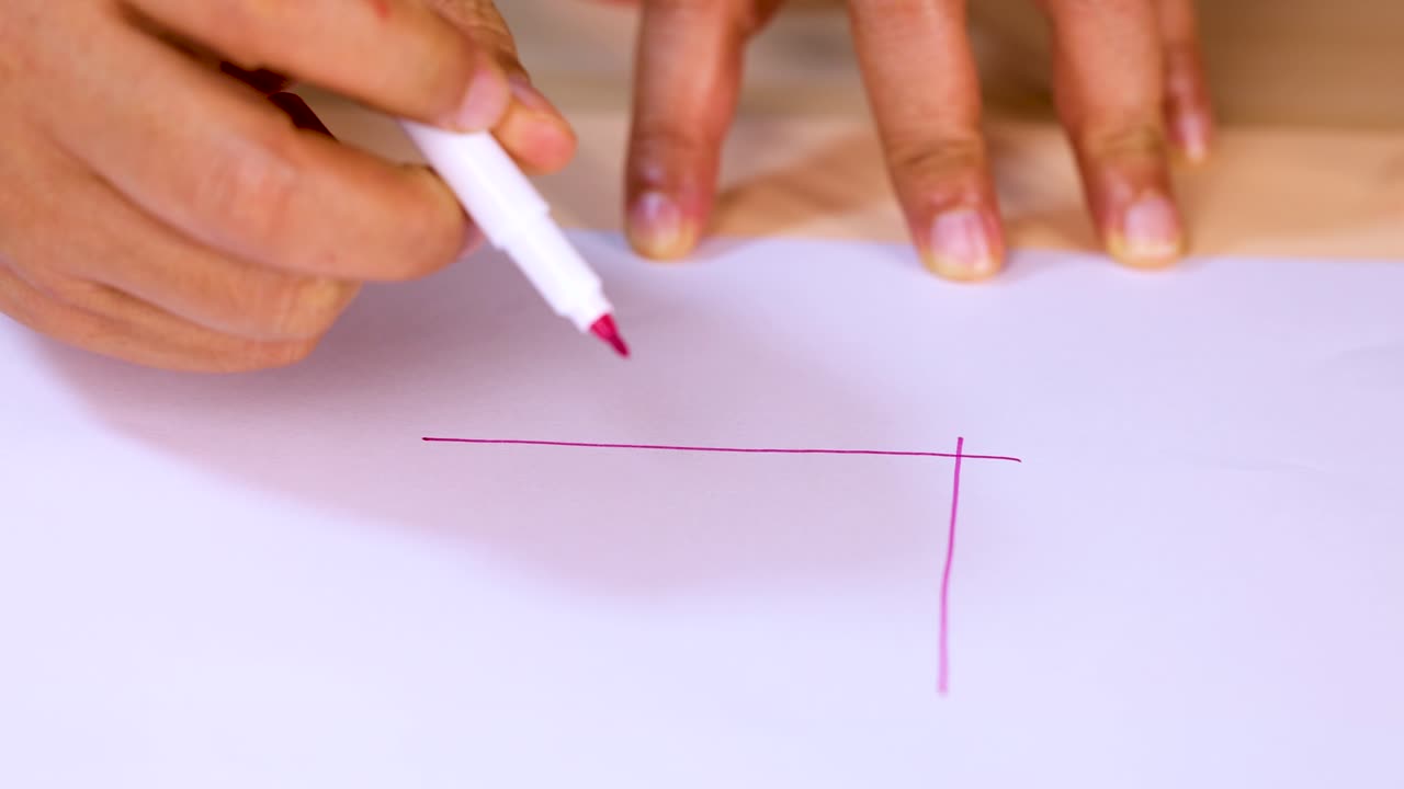 Close-up of hand drawing checklist boxes with pink marker on white paper, steady camera
