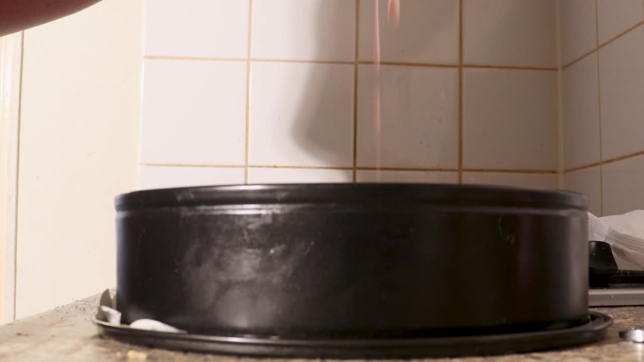 Video mentre si versa l'impasto della torta in uno stampo per torta.