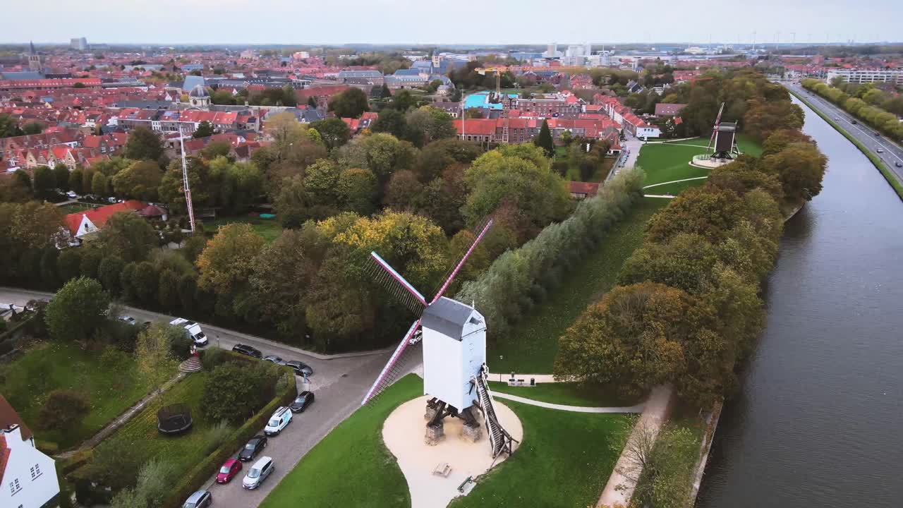 vista aérea de un molino de viento con automóviles conduciendo por inbruges, bélgica, ciudad, canales, medieval, arquitectura, patrimonio de la humanidad de la unesco, histórico, turismo, cultura