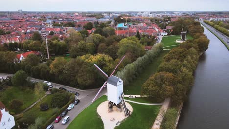 Aerial-view-of-a-windmill-with-cars-driving-by-inBruges,-Belgium,-City,-Canals,-Medieval,-Architecture,-UNESCO-World-Heritage-Site,-Historic,-Tourism,-Culture