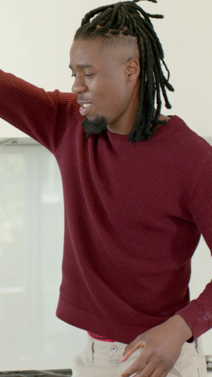 Vertical video: After hand contact man in burgundy knit reaching kitchen counter to grab glass jar
