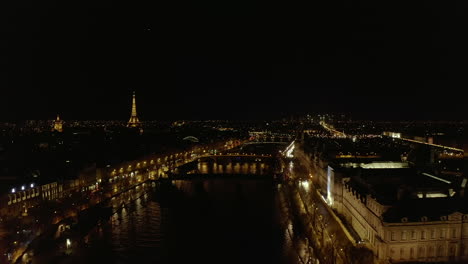 Volar-Sobre-La-Ciudad-De-Noche.-Río-Sena-Y-Sus-Puentes.-Edificios-Iluminados-Y-Puntos-De-Referencia.-París,-Francia