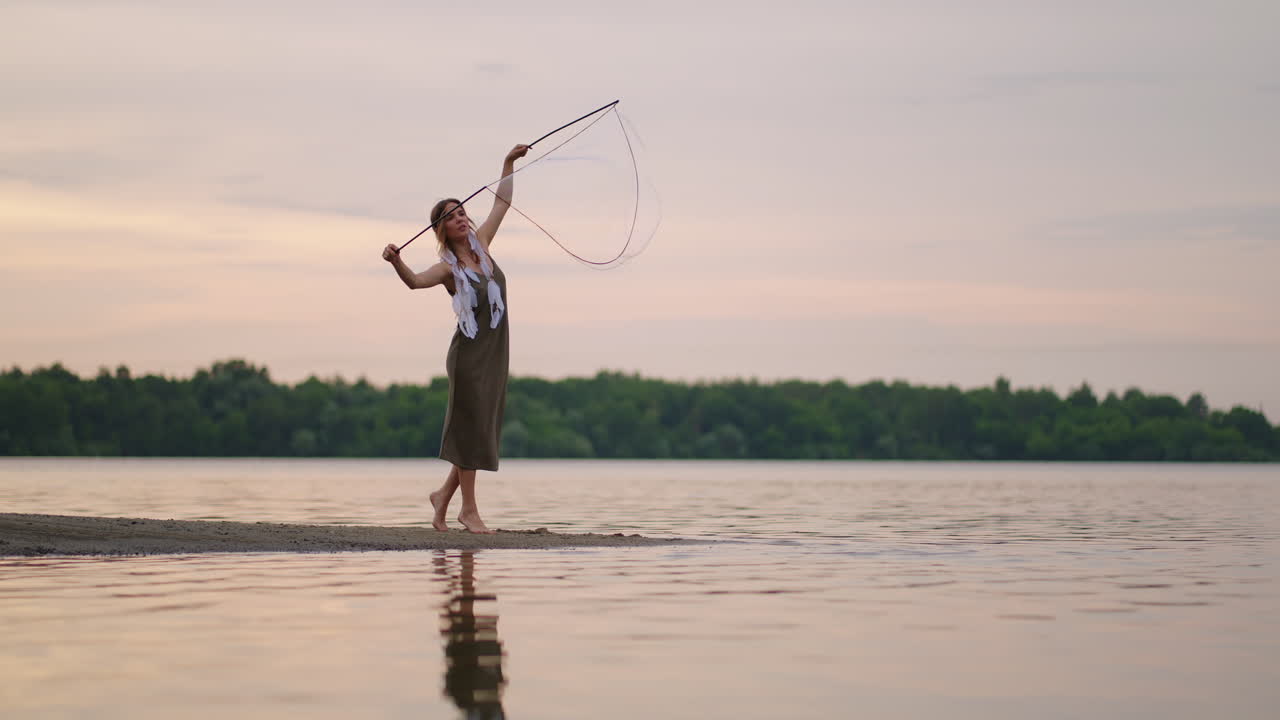 молодая девушка-художник показывает магические трюки с помощью огромных мыльных пузырьков. создать мыльные пузырьки с помощью палок и веревки на закате, чтобы показать театральное цирковое шоу